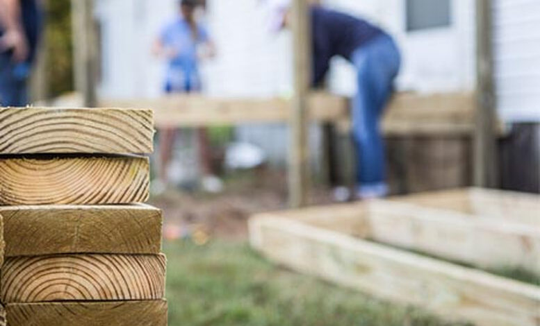 stack of deck boards with construction in the background