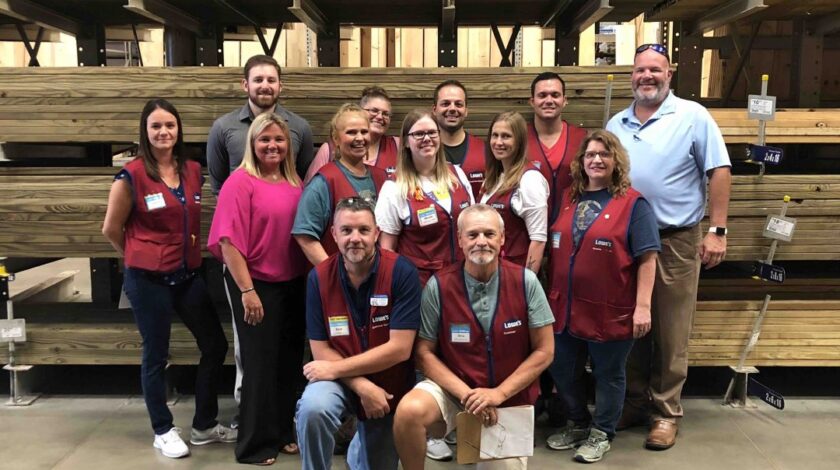 GHP and Lowes teams posing in front of lumber