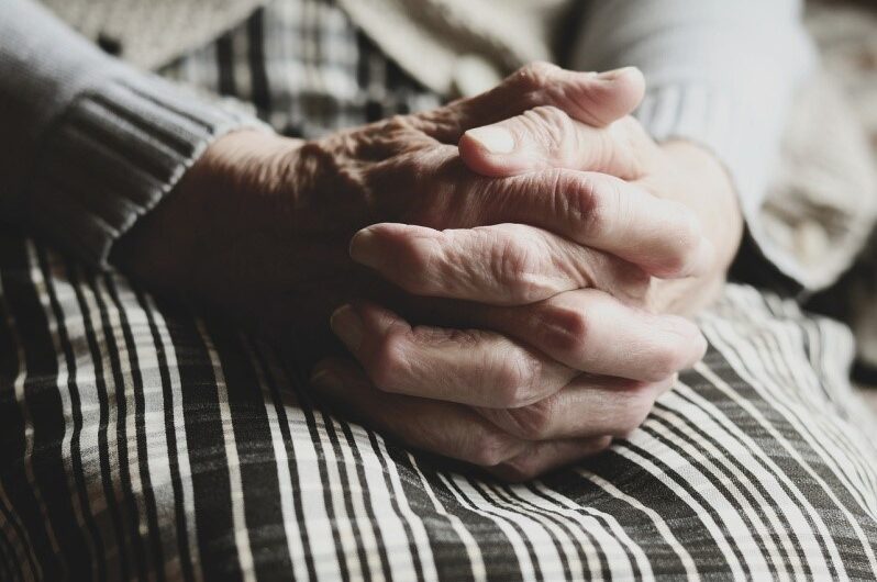 older lady with hands clasped in her lap